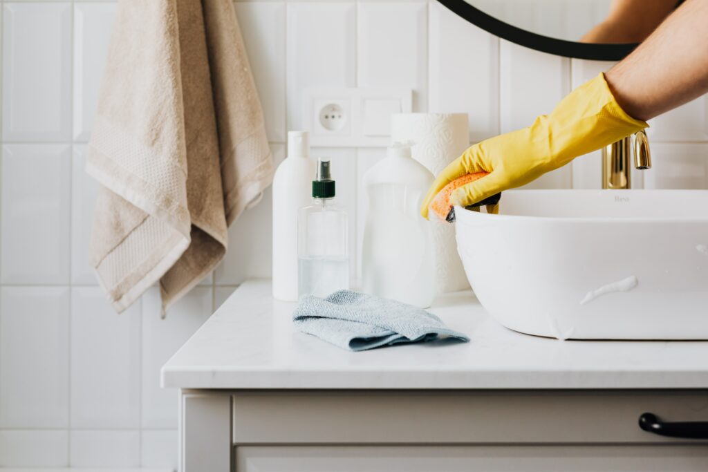 Person cleaning a vacation rental sink