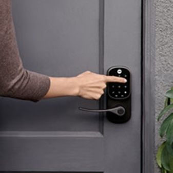 Hand operating Yale Assure smart lock fixed on a door