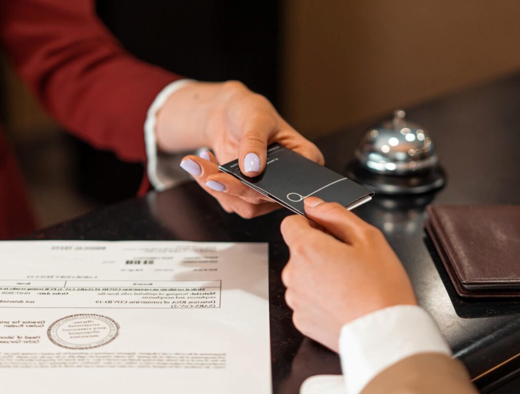 Person being handed a hotel keycard at the front desk