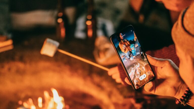 Phone filming a video of someone roasting a marshmallow over a fire
