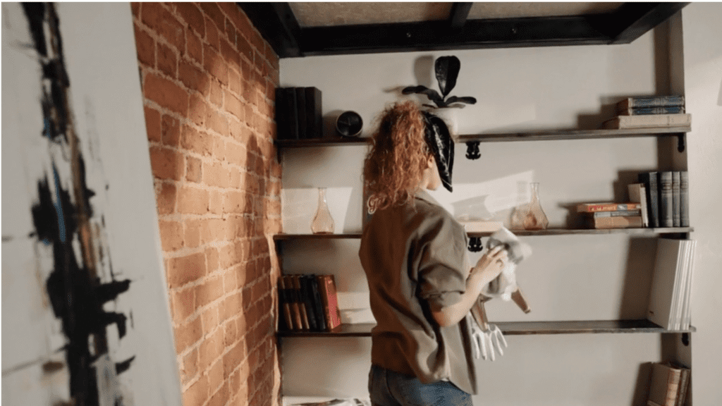 Person cleaning a shelf