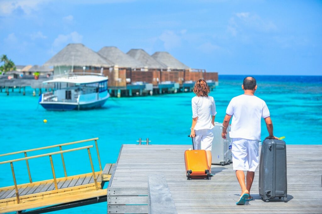 Travelers carrying suitcases on dock
