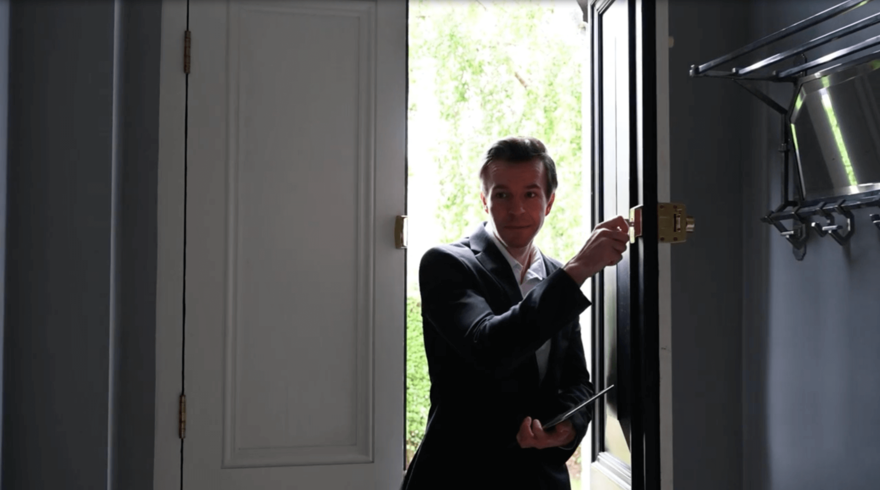 person in suit entering a home