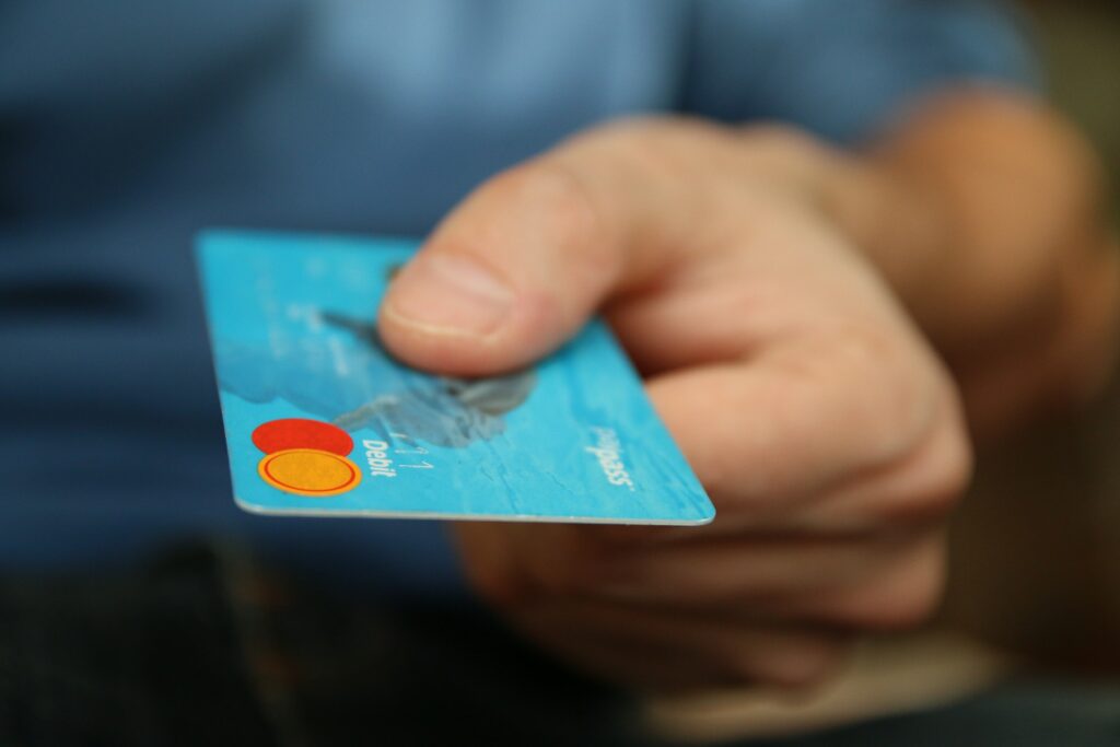 A photo of a man holding out a card to suggest fraud