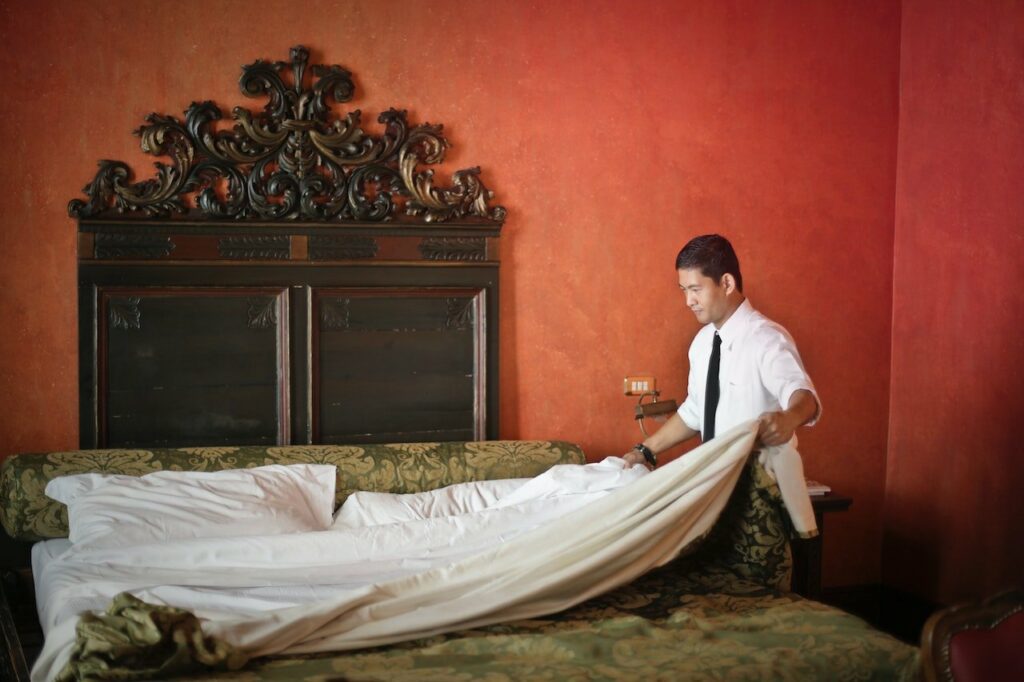 A Man turning down a couch bed in a hotel room