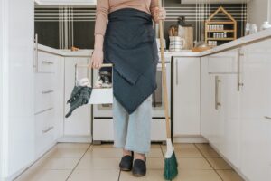 Airbnb Cleaning photo of cleaner holding broom and cleaning supplies